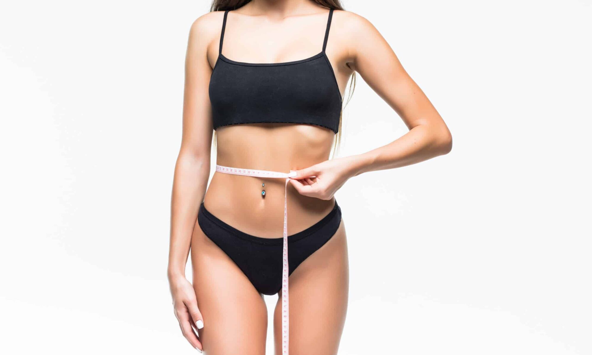 Slim girl in black underwear with a measuring ribbon at the waist. Photo of beautiful brunette girl with perfect body. Fitness or body care concept
